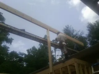 Carpenter setting a ridge beam over a new addition frame — Ice Dam Removal by Roofing Brothers in Riverton