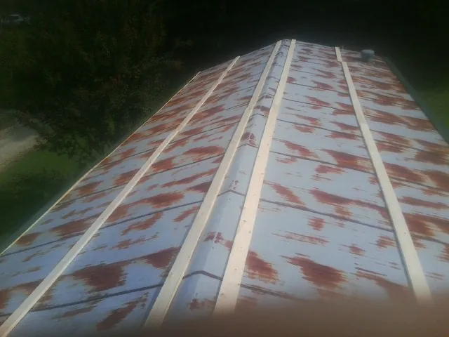 Rusted metal roof panels with new wood purlins before replacement — Storm Damage Roof Repair in Riverton by Roofing Brothers