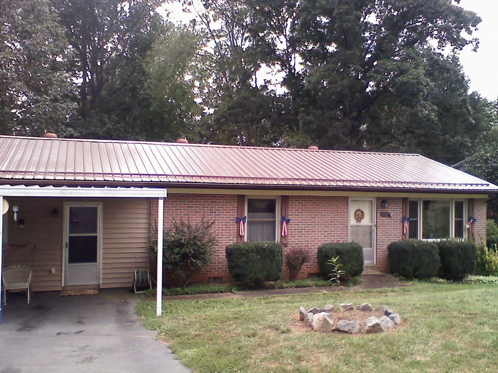 Bronze metal roof and carport on a brick ranch home — Roof Repair work by our crew in Riverton